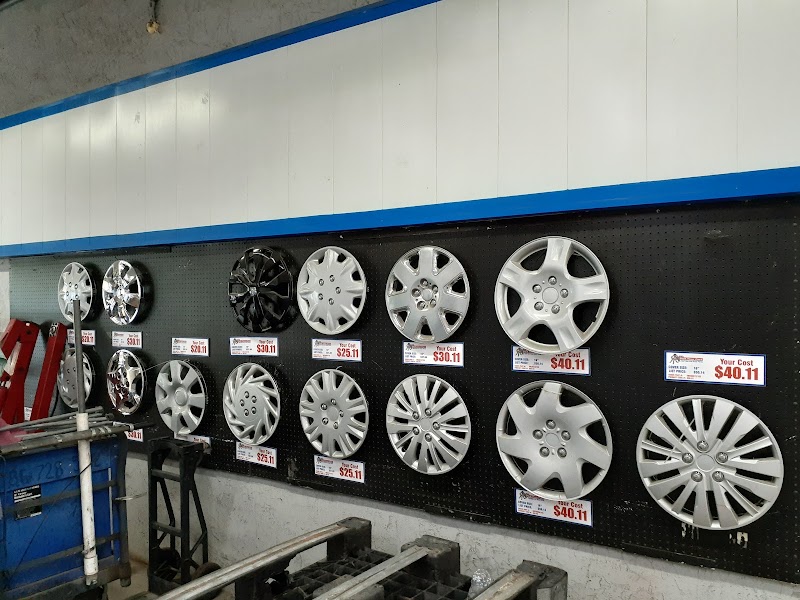 A wall of used hubcaps with price tags inside the U Pull It Davie store