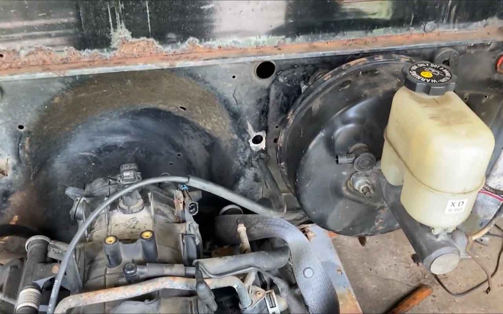 Power brake booster next to the engine
