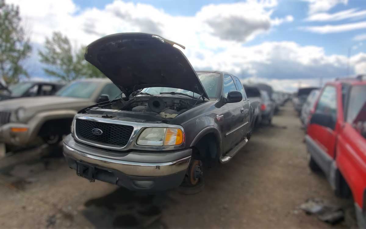 Junkyard with Ford F-150 trucks and parts