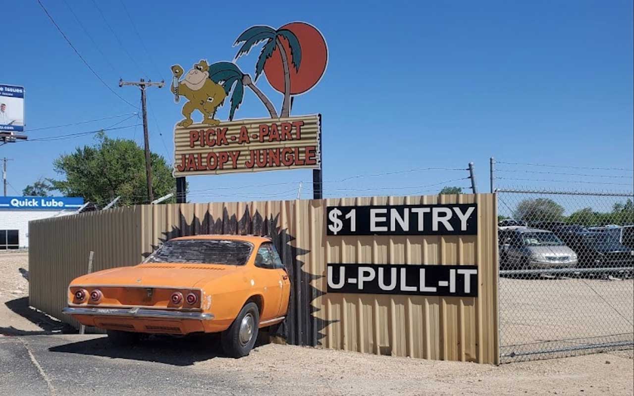 A junkyard entrance with posted entry fee information